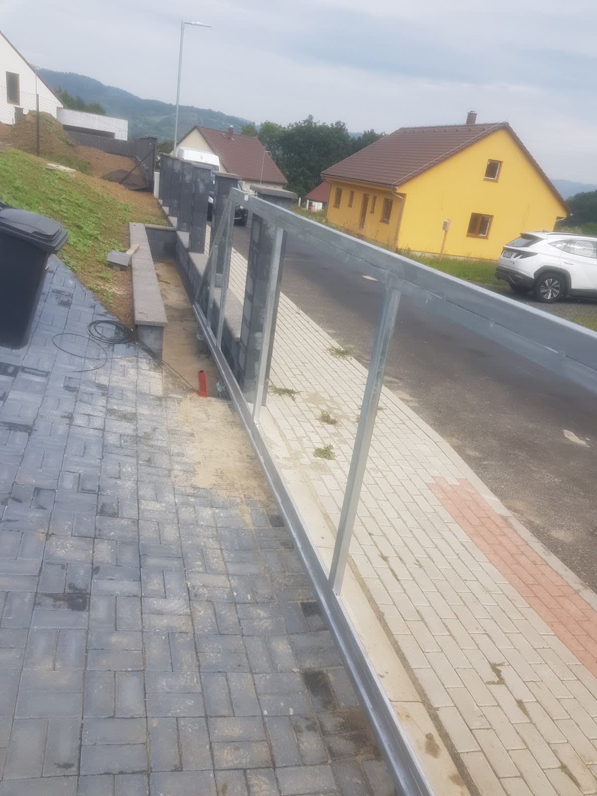Kované schodišťové zábradlí s obloučky nad dřevěným schodištěm